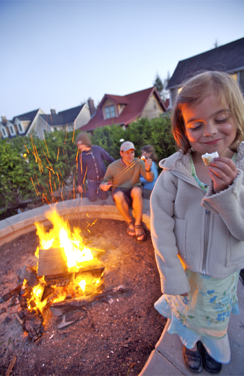 Little girl roasting marshmallows with her family